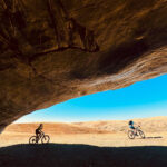 Mountain bikers under a rock formation